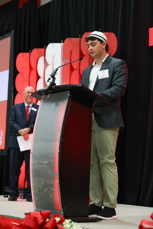 a man standing at a podium with a microphone