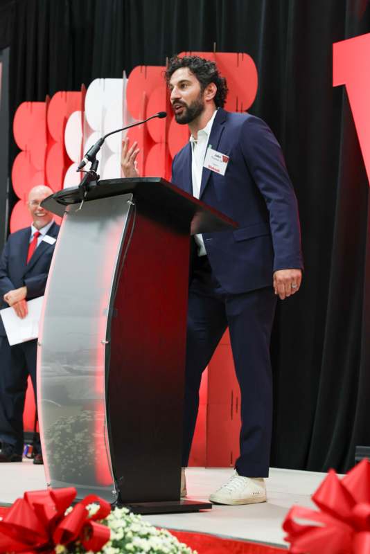 a man standing at a podium with a microphone