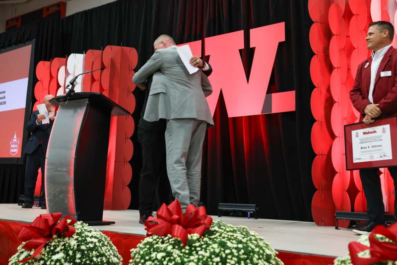 two men on a stage hugging