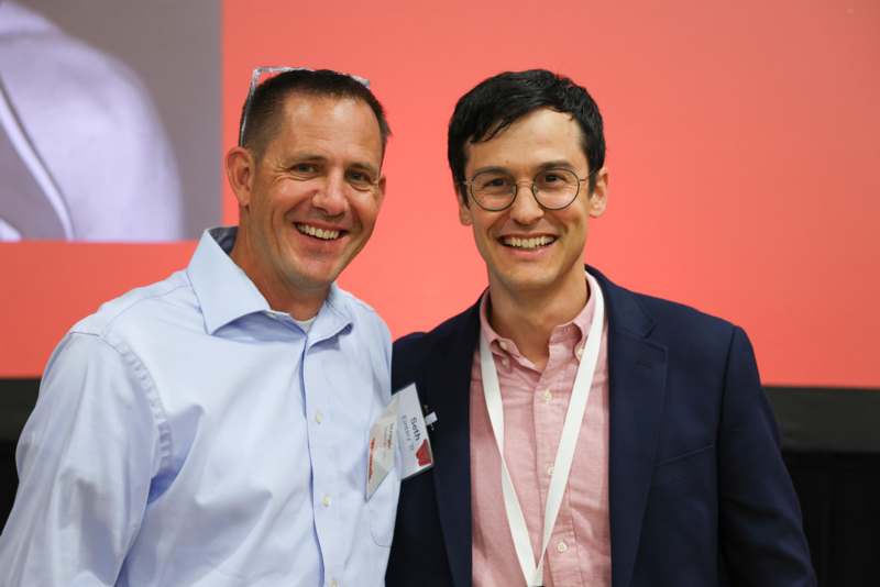 a couple of men smiling at the camera