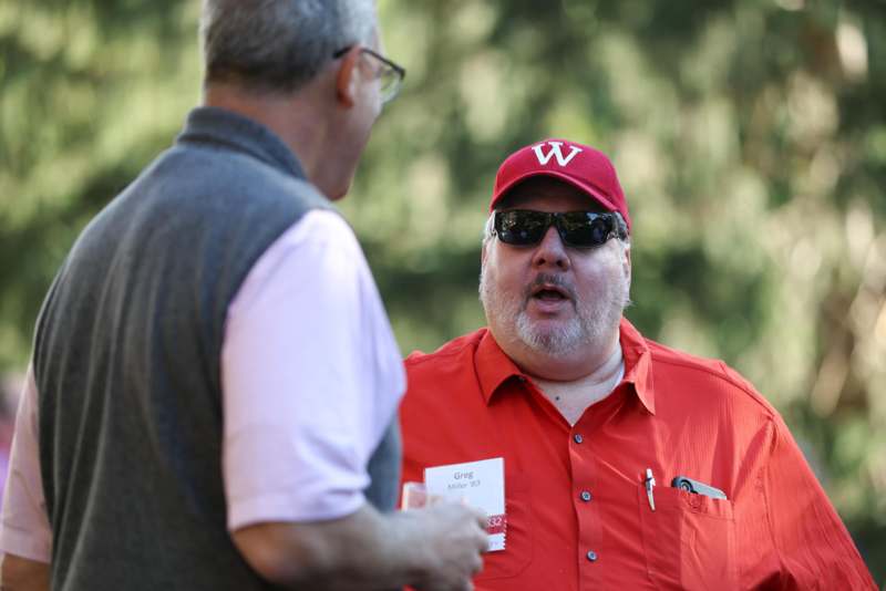 a man in a red shirt talking to another man