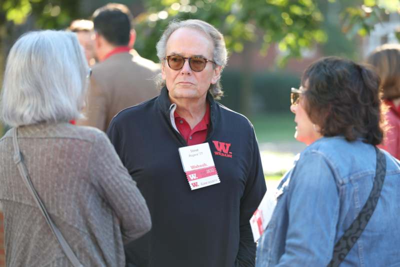 a man wearing sunglasses and a name tag standing next to a woman