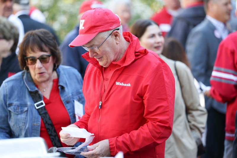 a man in red jacket looking at paper