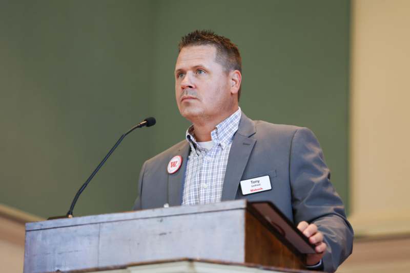 a man standing at a podium with a microphone