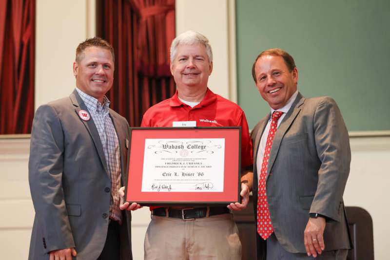a group of men holding a diploma