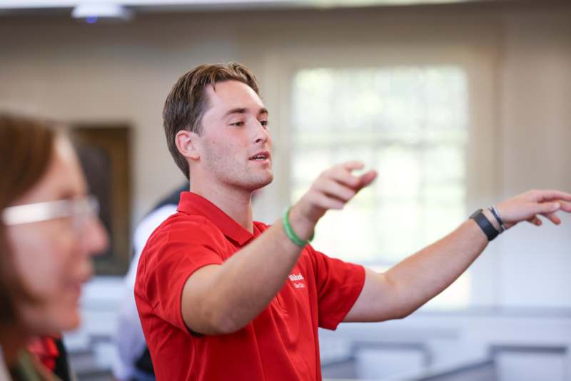 a man in a red shirt pointing his fingers