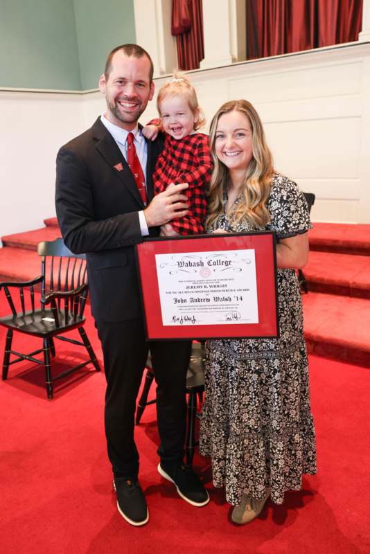 a man and woman holding a child