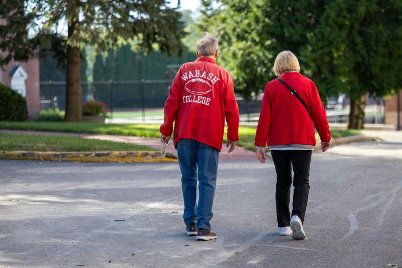 a man and woman walking on a road