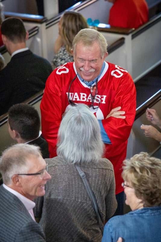 a man in a red jersey standing in a crowd