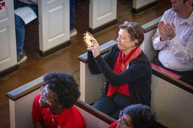a woman taking a selfie with a group of people