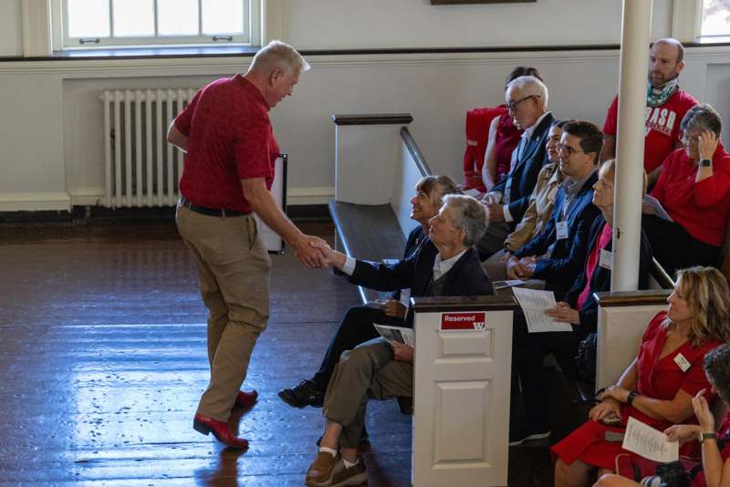 a man shaking hands with a group of people