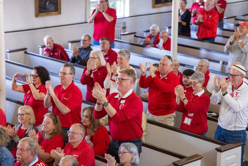 a group of people in red shirts clapping