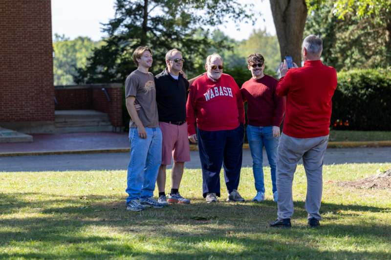 a group of men standing in a grassy area