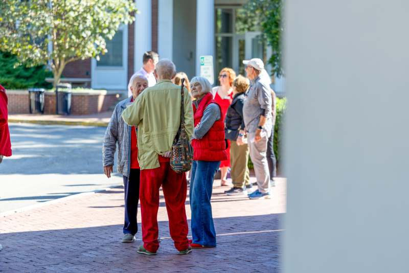 a group of people standing on a sidewalk