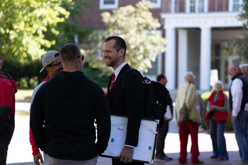 a man in a suit holding a clipboard and a man in a black jacket