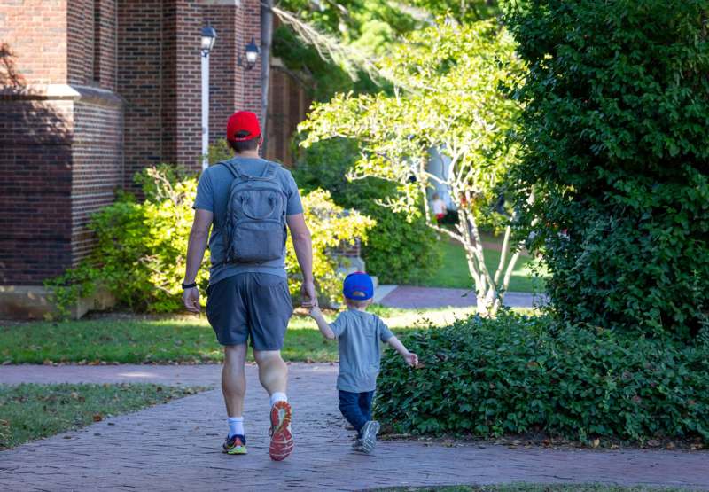a man and child walking on a brick path