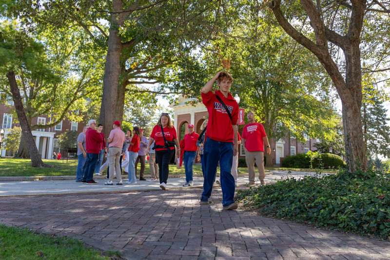 a group of people walking on a brick path