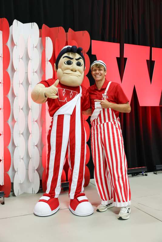 a man in a garment posing with a person in striped pants