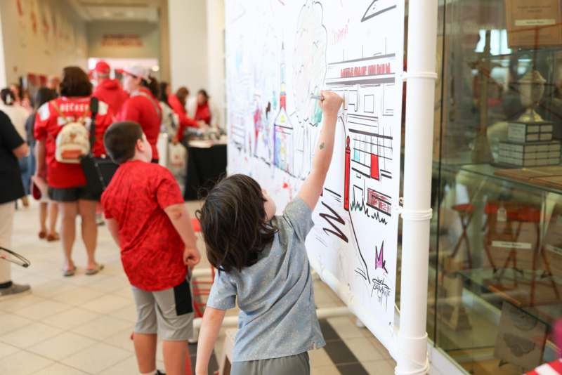 a child drawing on a white board