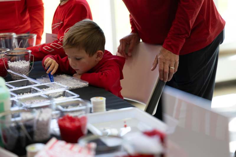 a boy in red shirt at a table with a table full of food