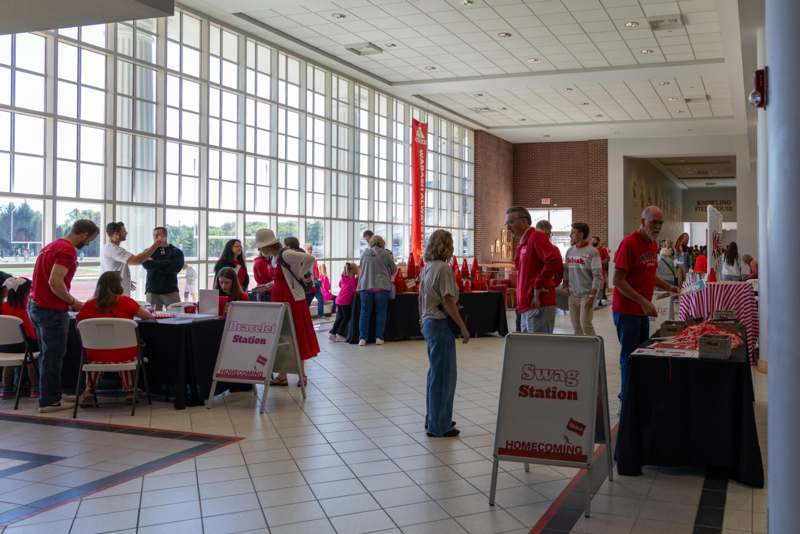 a group of people in a room with tables and signs