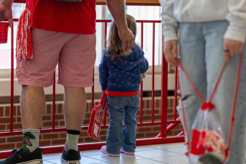 a child standing in front of a red gate