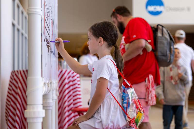a girl drawing on a white board