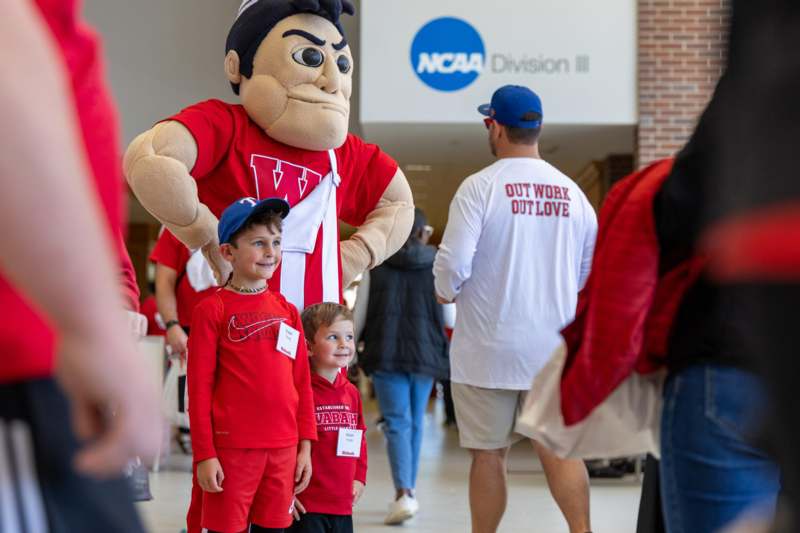 a group of people in a room with a mascot