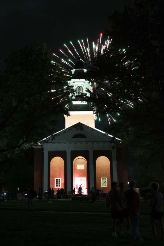 fireworks exploding in the sky over a building