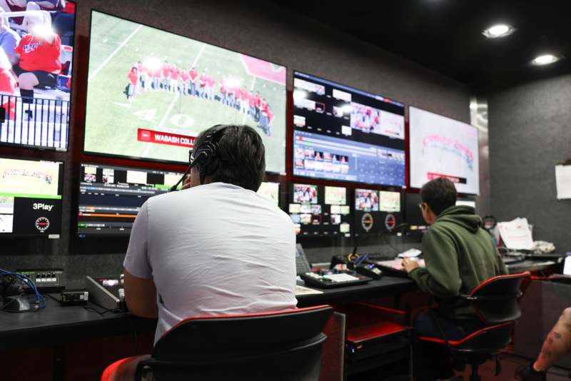 a man sitting in front of a television screen