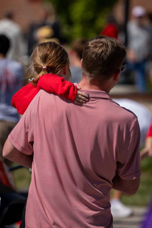 a man holding a child on his shoulders