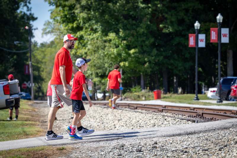 a man and boy walking on a train track