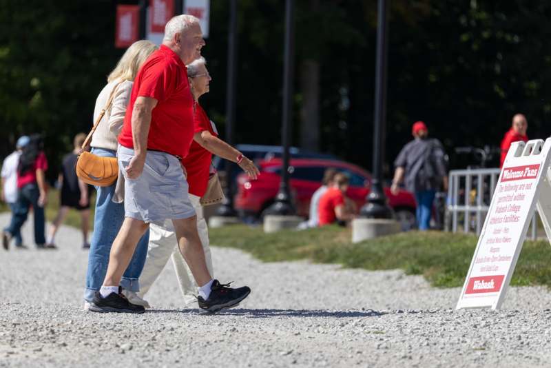 a group of people walking on a gravel path