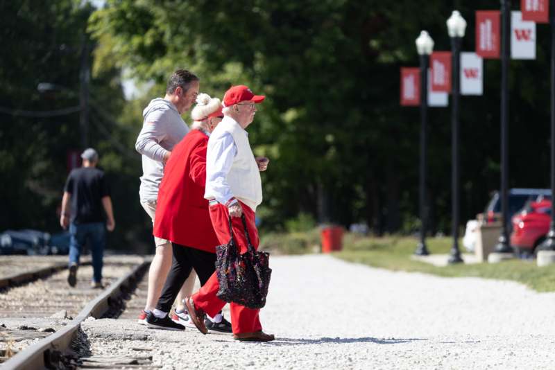 a group of people walking on a gravel path