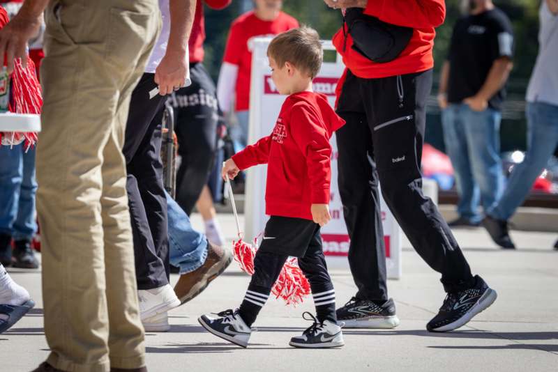 a boy walking with pom poms