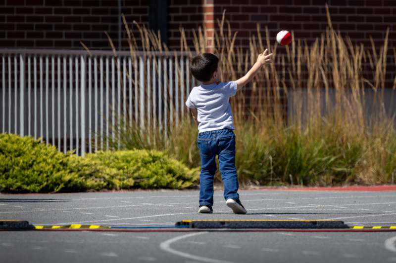 a child reaching for a ball