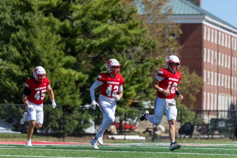 a group of football players running on a field