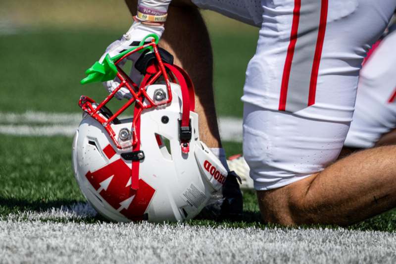 a football player kneeling on the ground with a helmet