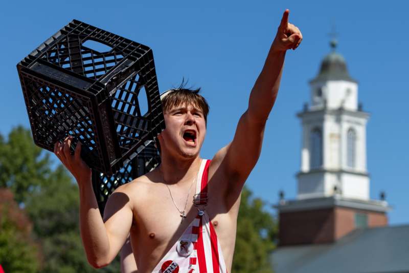 a man holding a black crate and pointing at something