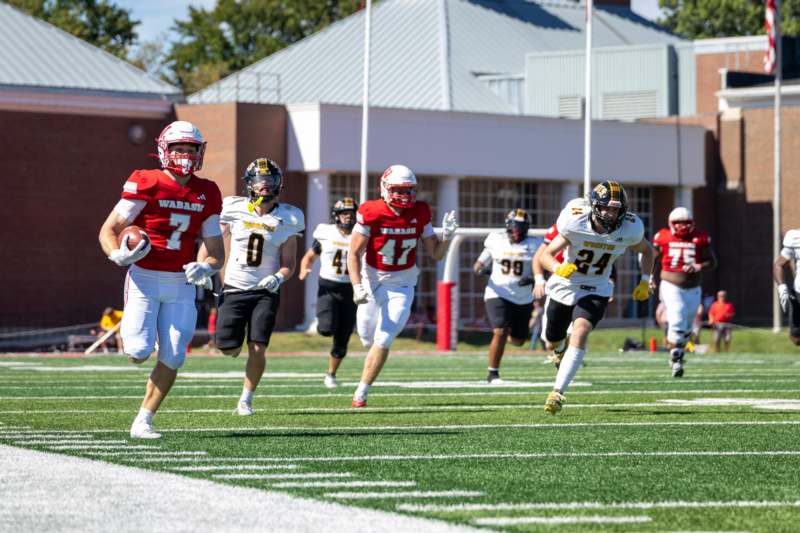 a group of football players running on a field