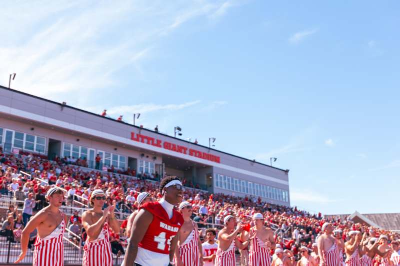 a group of people in red and white uniforms in a stadium