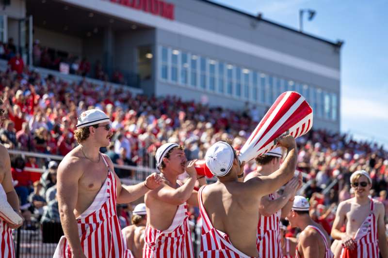 a group of men wearing striped aprons and hats