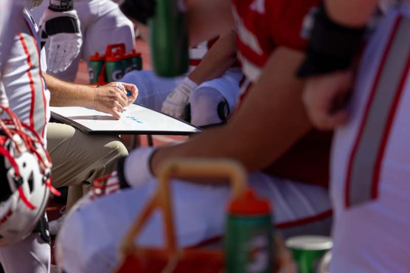 a coach writing on a clipboard