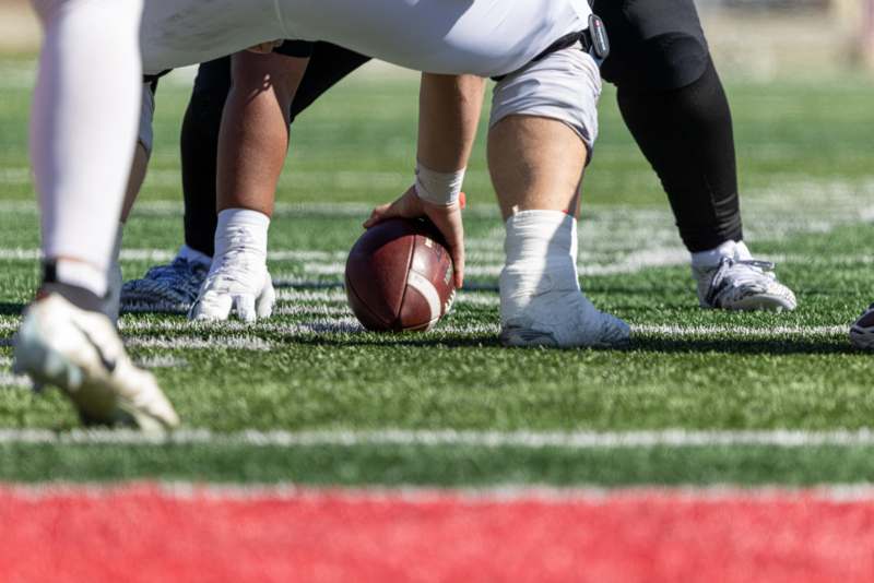 a football player holding a football on the field