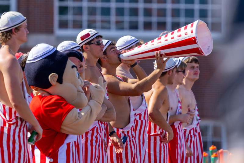 a group of people wearing striped overalls and a megaphone