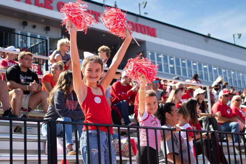 a group of people in bleachers holding pom poms