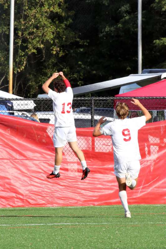 two men in white uniforms jumping in the air