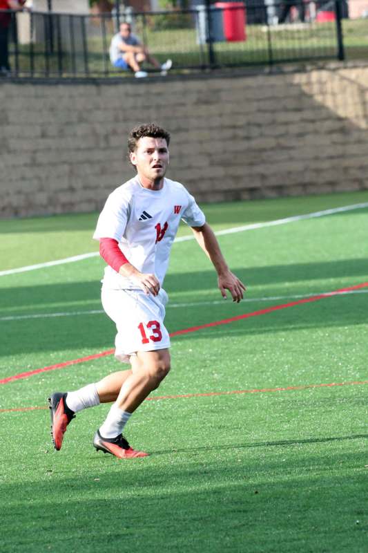 a man in a white uniform running on a field