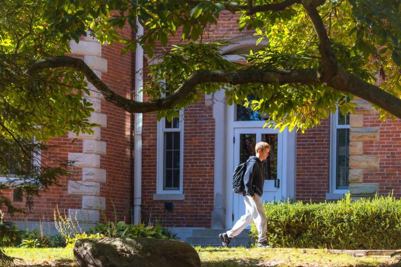 a man walking in front of a brick building