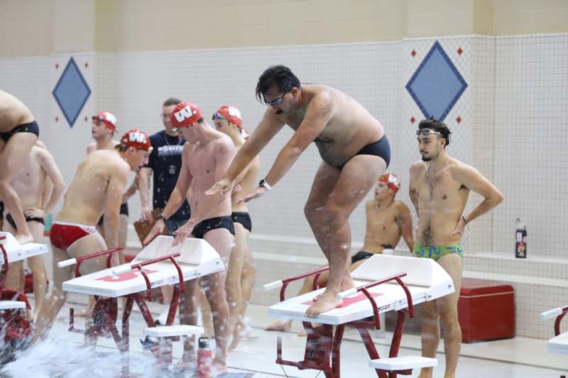 a group of men in swimsuits in a swimming pool